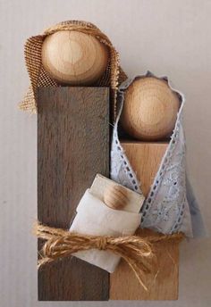 two wooden pegs are sitting on top of some fabric and wood pieces, one is tied with twine