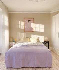 a bedroom with a bed, nightstands and pictures on the wall above it's headboard