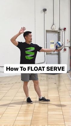 a man standing on top of a hard wood floor holding a volleyball in his hand