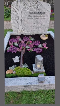 a grave with a tree and flowers in it