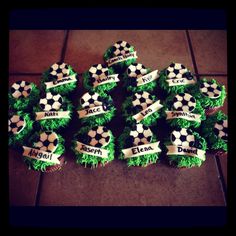 cupcakes with soccer balls and name tags on them are sitting on the floor