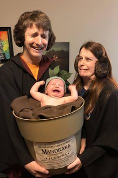 a man and woman holding a baby in a bucket