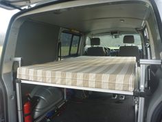 the back end of a van with a mattress on it