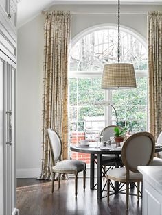 a dining room table with four chairs and a lamp hanging from the ceiling over it