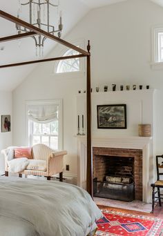 a bedroom with a four poster bed sitting next to a fireplace