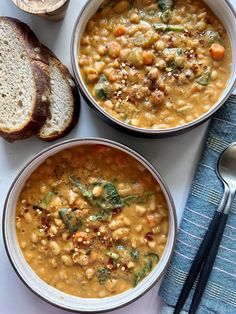 two bowls of soup with bread on the side