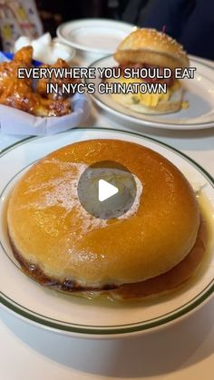 a white plate topped with a donut covered in icing next to other plates filled with food