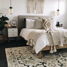 a bed with white sheets and pillows on top of it next to a rug in front of a window