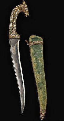 an old dagger and sheath are displayed on a black background with gold trimmings