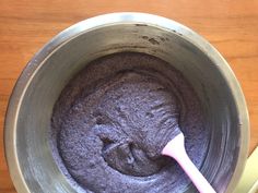 a metal bowl filled with some kind of brownie batter on top of a wooden table