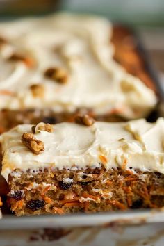 carrot cake with white frosting and nuts on top