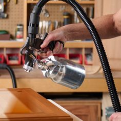 a man is using a vacuum to clean a kitchen counter top with a hand held hose