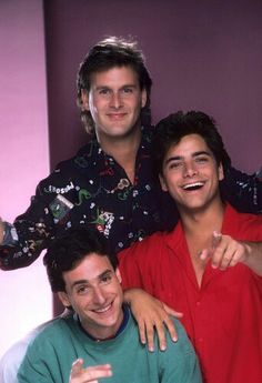 three young men posing for the camera with their arms around each other