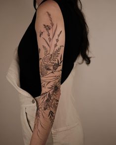 a woman's arm with flowers and leaves on the back of her body,