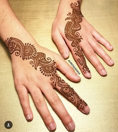 two hands with henna tattoos on them