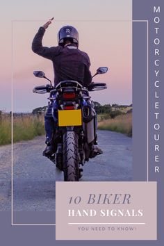 a man riding on the back of a motorcycle down a road with his hand in the air