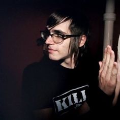 a man in black shirt and glasses holding a white frisbee with both hands