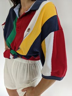 Bright & colorful striped polo by Tommy Hilfiger from the 90s. Polo has a collared neckline with button closures, short sleeves and a signature embroidered crest at the front. Tag reads Tommy Hilfiger A couple very faint darkened spots at the front lower & some speckled discoloration at the end of the left sleeve. Spring Striped Polo Shirt, Striped Preppy Polo Shirt, Preppy Striped Polo Shirt, Retro Short Sleeve Polo Shirt With Striped Collar, Spring Polo Shirt With Contrast Stripes, Retro Striped Polo Shirt With Polo Collar, Retro Striped Polo Shirt, Preppy Striped Polo Collar Top, Retro Polo Collar Top With Striped Detail