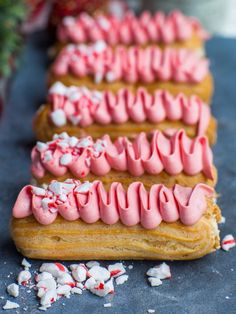 three desserts with pink frosting and white sprinkles on top of them