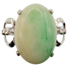 Introducing our exquisite Vintage Solitaire White & Green Jade Ring in White Gold, a captivating piece that seamlessly combines the elegance of white gold with the allure of a stunning cabochon cut jade gemstone. This unique ring showcases a remarkable 13.40mm x 9.40mm cabochon cut jade, set in a lustrous white gold band. The focal point of this ring is the mesmerizing cabochon cut jade gemstone. Known for its smooth, rounded surface and captivating color, the jade exhibits a beautiful blend of