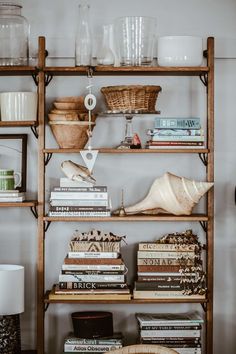 a shelf filled with lots of books next to a lamp