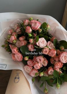 a bouquet of pink roses sitting on top of a table