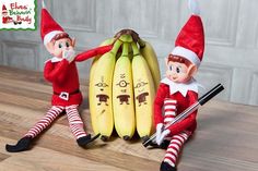 two elfs sitting next to bananas on a table