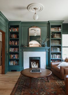 a living room filled with furniture and a fire place in front of a book shelf