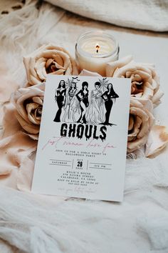 a candle and some flowers on a white sheet with the words ghouls printed on it