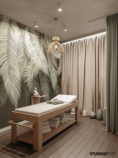 a spa room with a wooden table and white towels on the bottom shelf in front of a palm leaf wallpaper