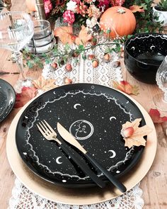 a table set with black plates and silverware