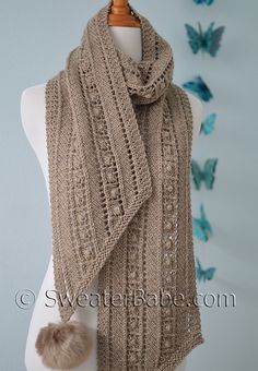 a knitted scarf with a pom - pom on the top and bottom