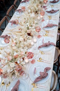 a long table is set with plates and napkins for an elegant dinner or party