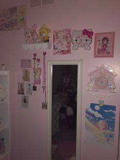 there is a pink room with hello kitty pictures on the wall and other items hanging on the walls