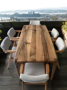 a wooden table sitting on top of a hard wood floor next to a white chair