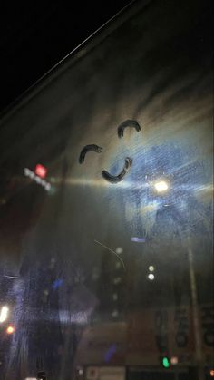 the reflection of a person's face is seen through a glass window at night