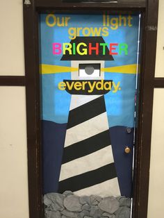 a door decorated with an image of a lighthouse and the words, our light grows brighter everyday