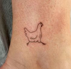 a small chicken tattoo on the ankle