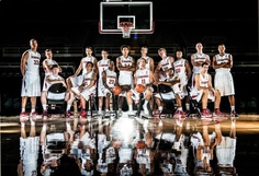 a group of young people standing on top of a basketball court next to each other