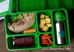 a green lunch box filled with lots of food