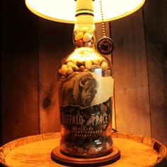 a bottle filled with rocks sitting on top of a wooden table next to a lamp