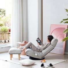 a woman sitting in a chair reading a book