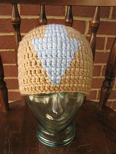 a crocheted hat sitting on top of a wooden chair