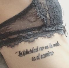 a woman with a tattoo on her stomach that reads, la felicididad no ess la mete, el camino