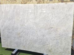 a large white marble slab sitting on top of a green carpeted floor next to a wall