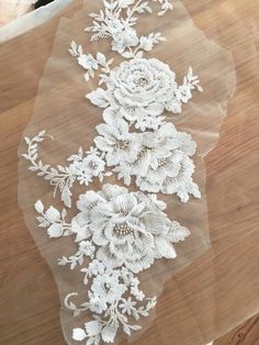 a white lace with flowers on a wooden surface