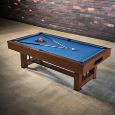 a pool table in front of a brick wall