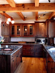 a large kitchen with wooden cabinets and granite counter tops, along with hardwood flooring