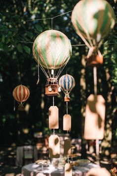 several hot air balloons are being flown in the sky above a table with white linens