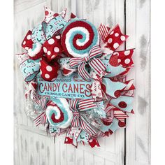 the candy cane wreath is hanging on a white door with red, white and blue decorations